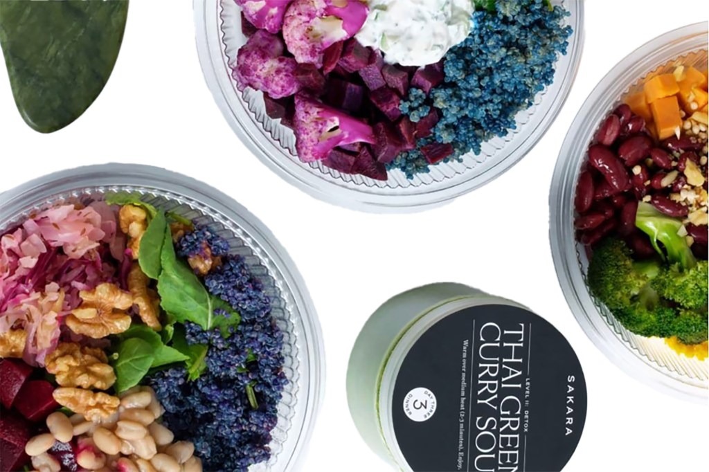 A flat lay of Sakara Level II detox meals and functional juice bottles.