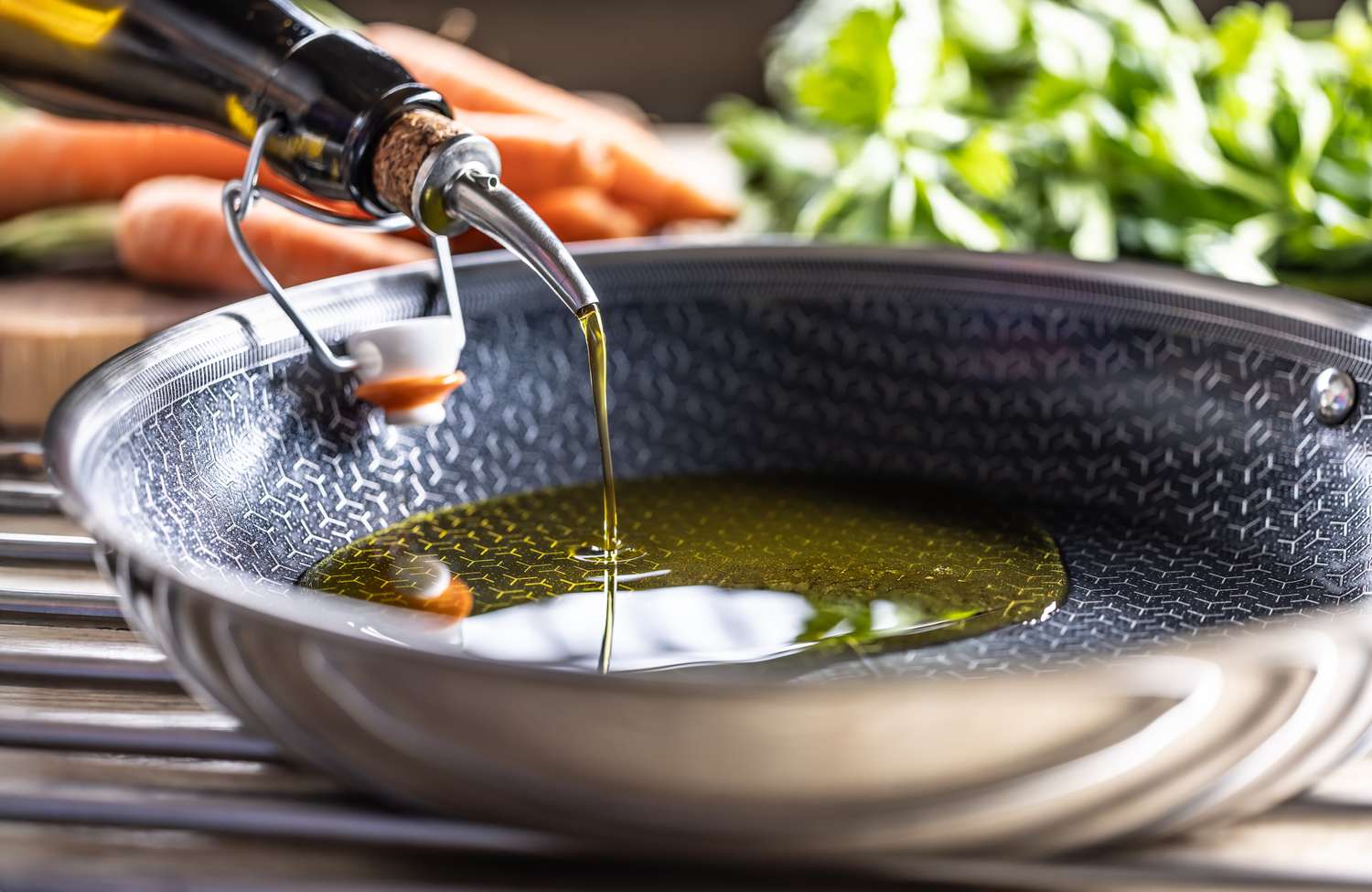 Olive oil being poured into a pan with fresh vegetables to illustrate heart-healthy cooking.