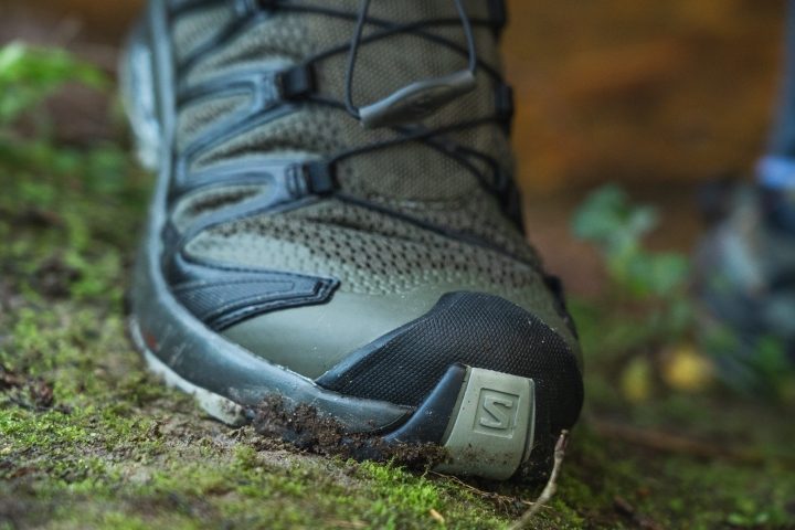 Detailed shot of a reinforced rubber bumper on the front of a Salomon shoe.
