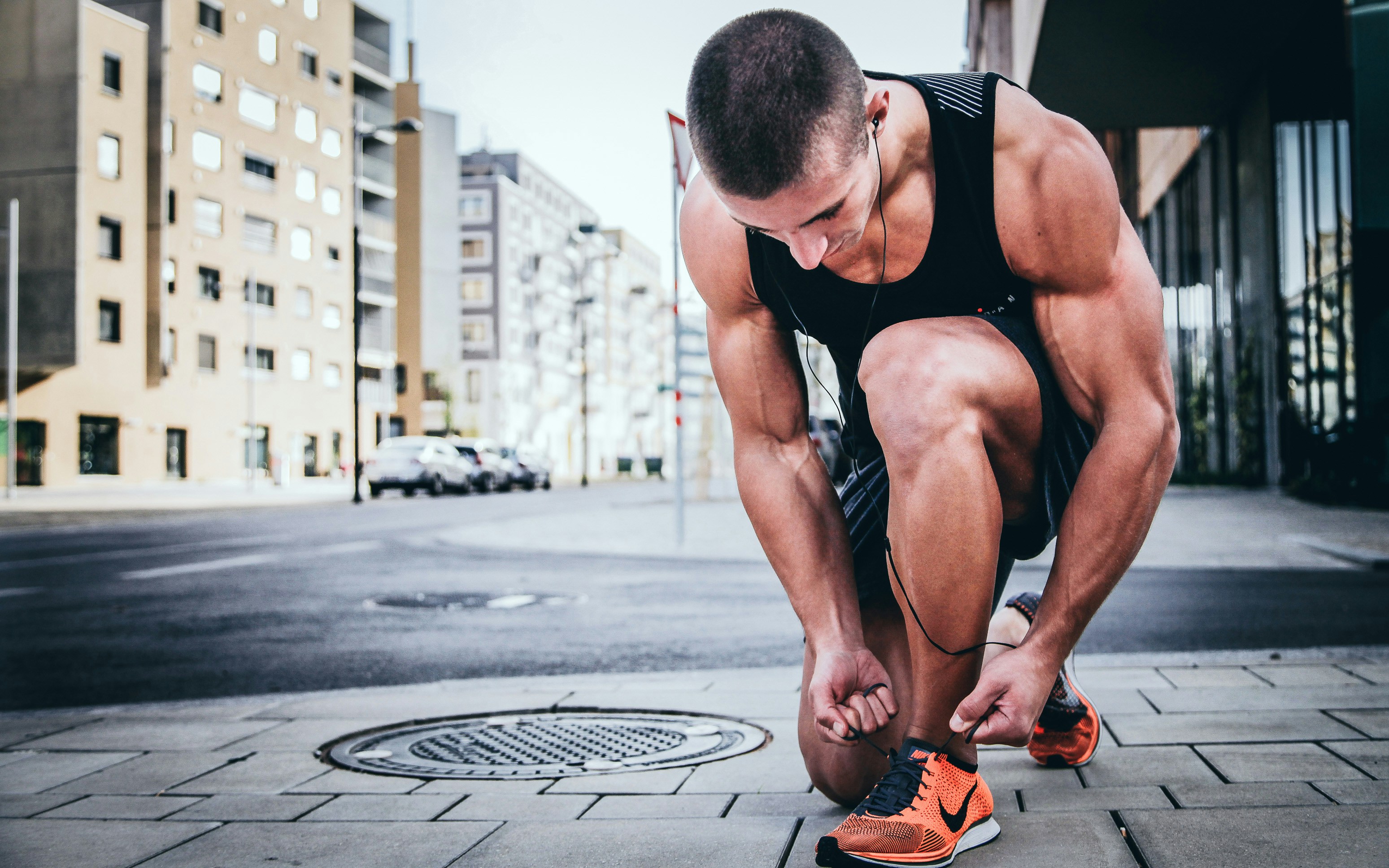 An individual performing dynamic leg stretches in an outdoor park setting.