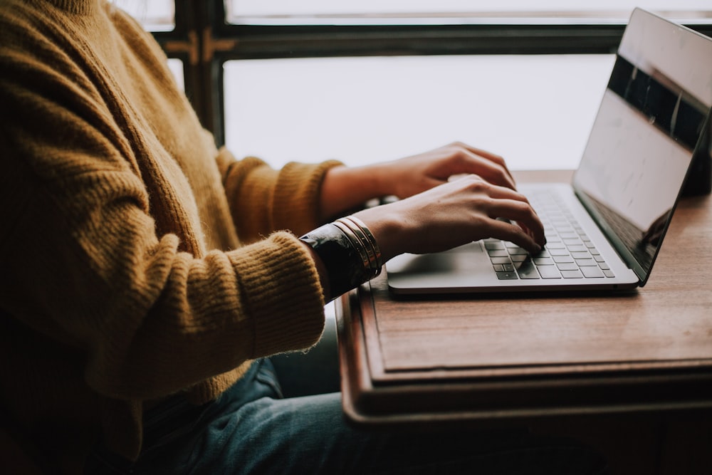 A person sitting at a tidy desk, focused on their laptop with no smartphone or other digital distractions in sight.
