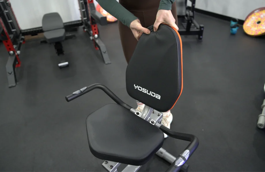 Close-up of a wide, padded recumbent bike seat and breathable mesh backrest.
