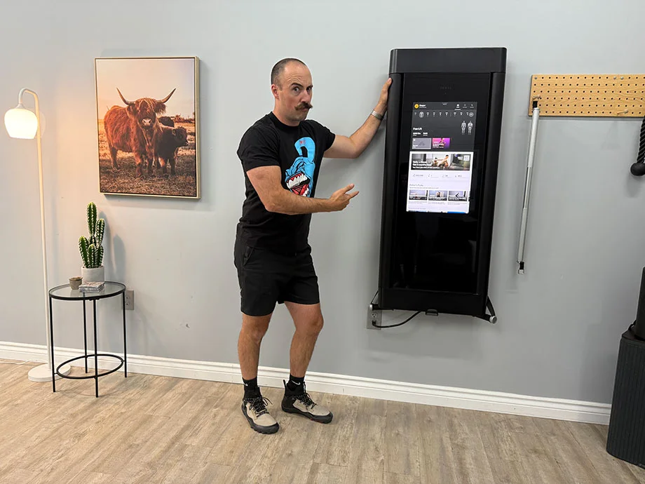 A sleek, wall-mounted Tonal smart gym system integrated into a modern home decor.