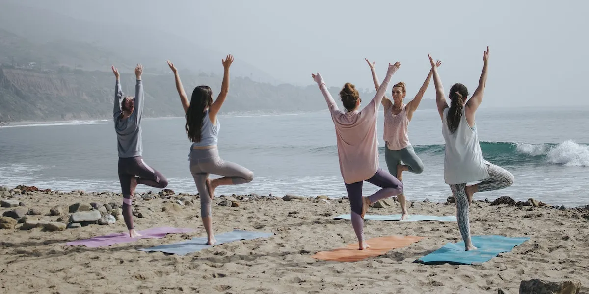 A woman in her 50s practicing a calm yoga pose on a mat.