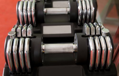 A modern selectorized adjustable dumbbell with a numbered weight dial.