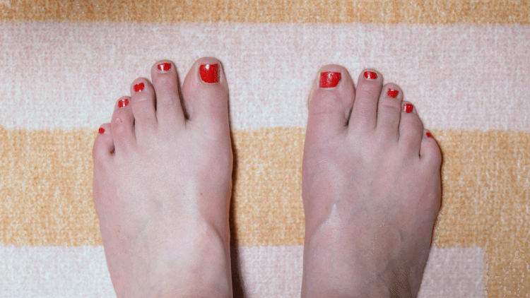 Top-down view of a foot performing wide toe spreads on a flat surface.