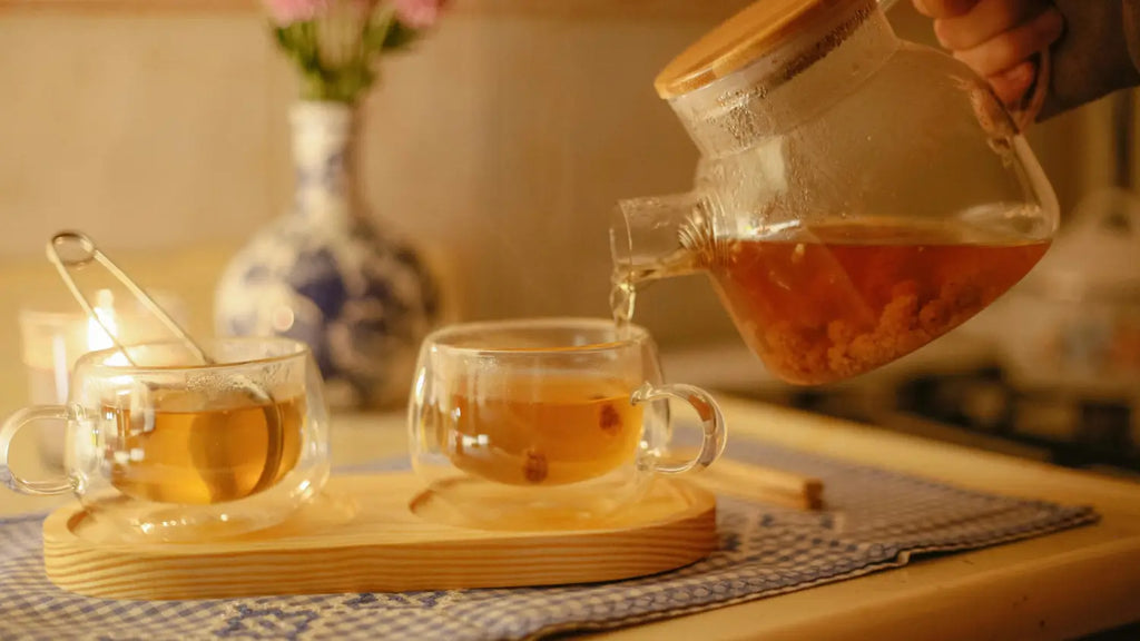 A steaming ceramic mug of herbal tea sitting on a wooden surface.