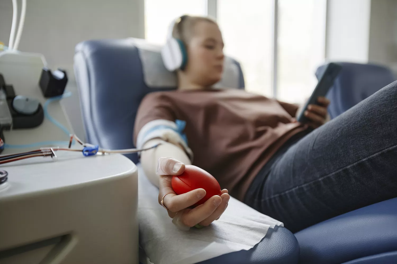 A healthcare professional performing a blood draw on a patient in a clinical setting.