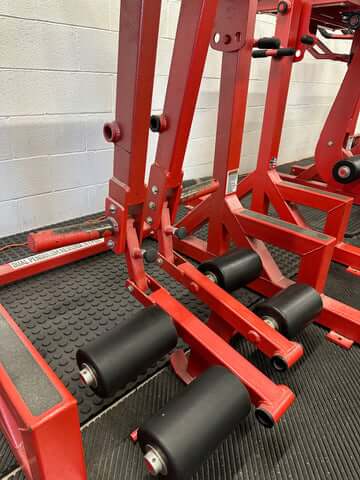 Close-up of the dual pendulum swing mechanism and ankle straps on a reverse hyper machine.