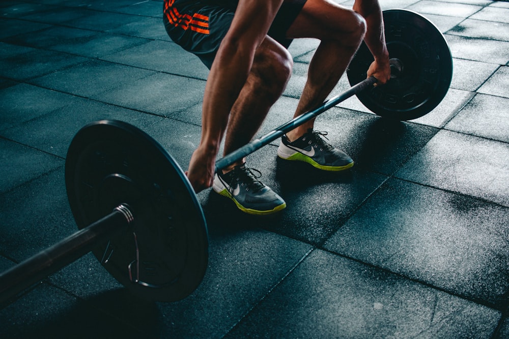 A person performing strength training exercises with dumbbells in a gym setting.