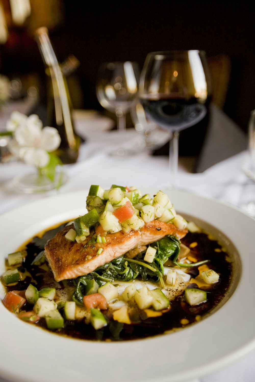 A grilled salmon fillet served with fresh herbs and lemon on a plate.