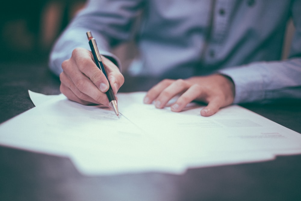 A woman writing a detailed list of health concerns in a journal