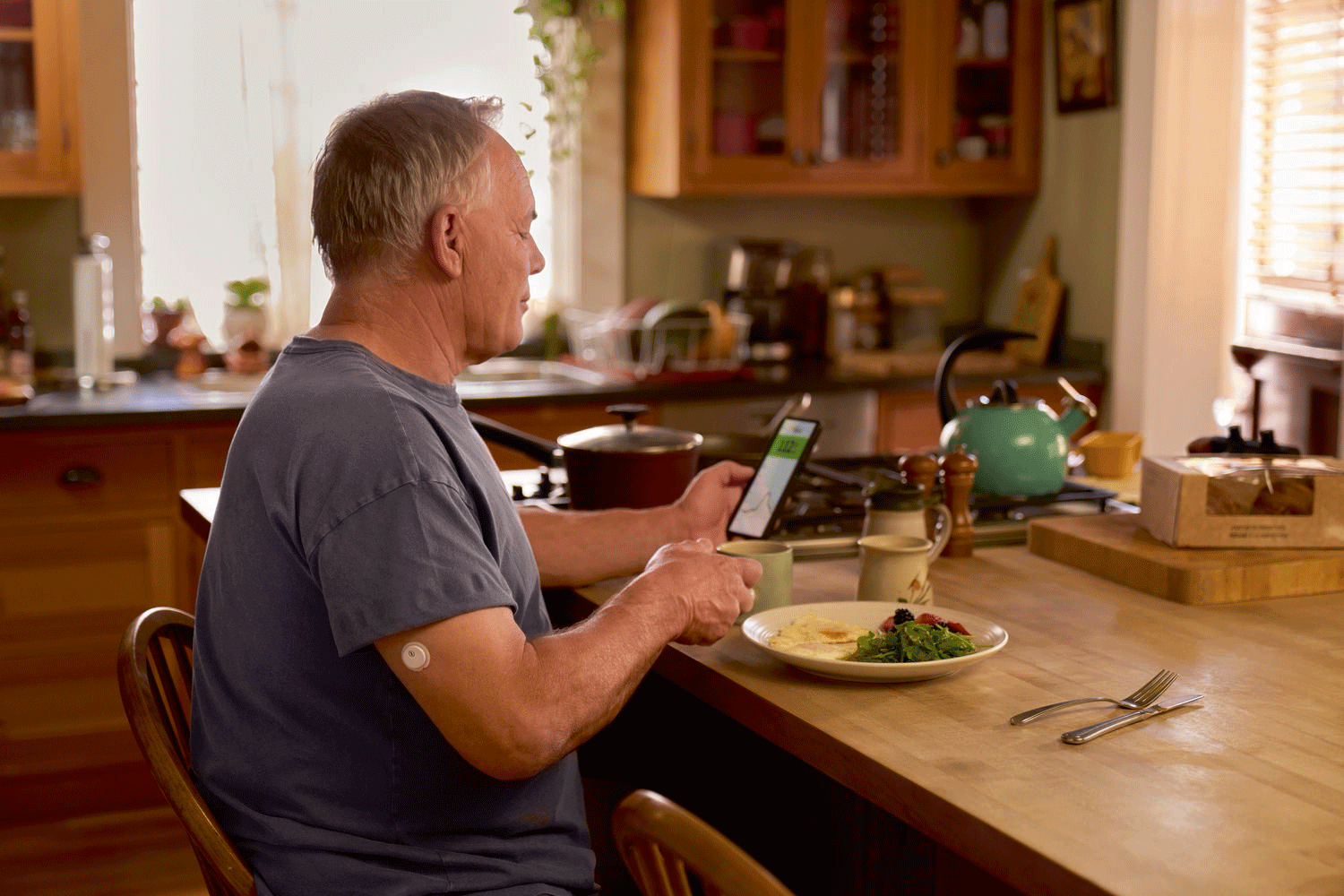 A user checking their glucose levels on a phone while eating breakfast to see their food response.
