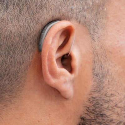A comparison display showing the physical size and design differences between Behind-the-Ear and In-the-Ear hearing aid models.