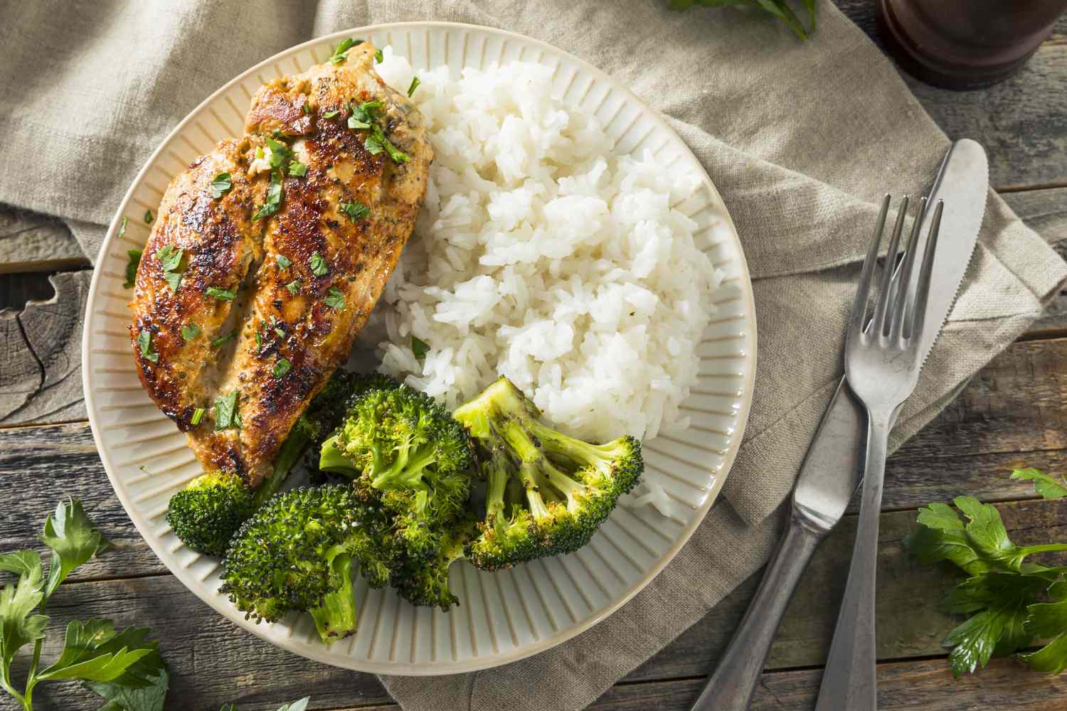 A simple healthy plate with grilled chicken breast, steamed broccoli, and white rice.