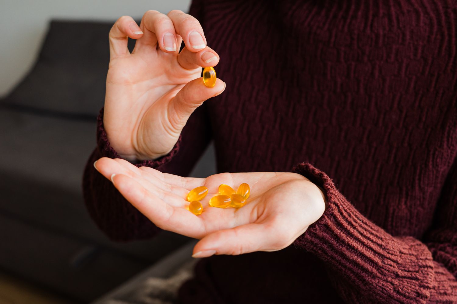 A close-up of a person holding vitamin capsules, representing lifestyle medicine and metabolic health.