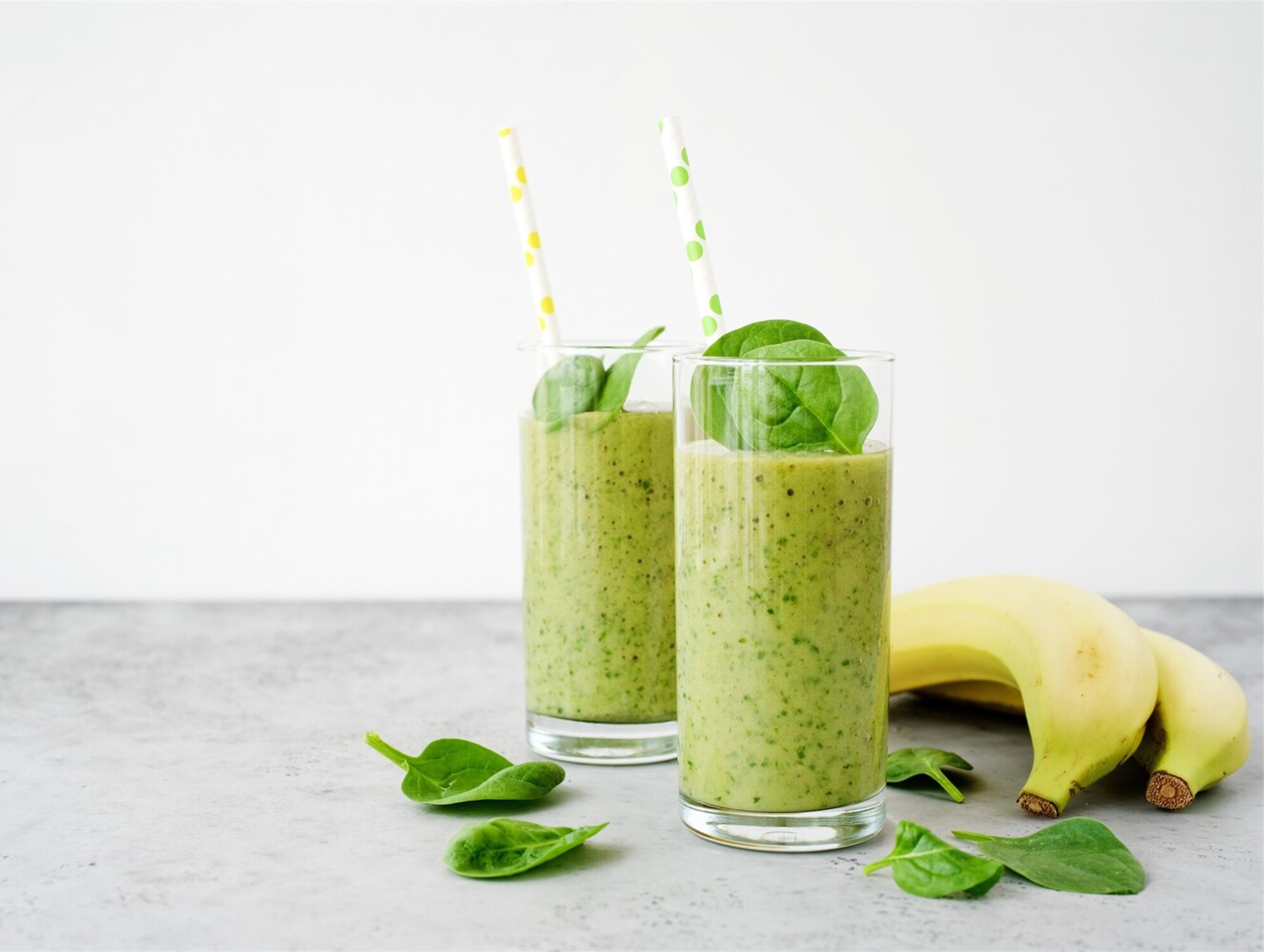 A vibrant green detox smoothie on a wooden table with fresh garnish.