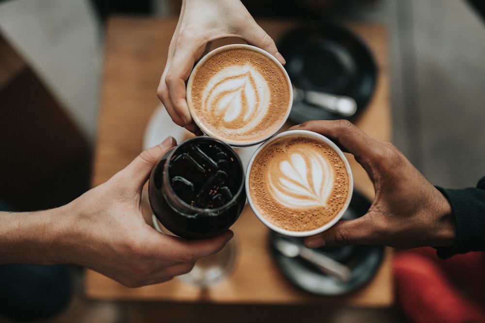 A single cup of black coffee served on a wooden table.
