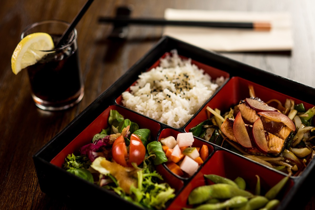 Bento box style meal prep containers filled with chicken and fresh vegetables.