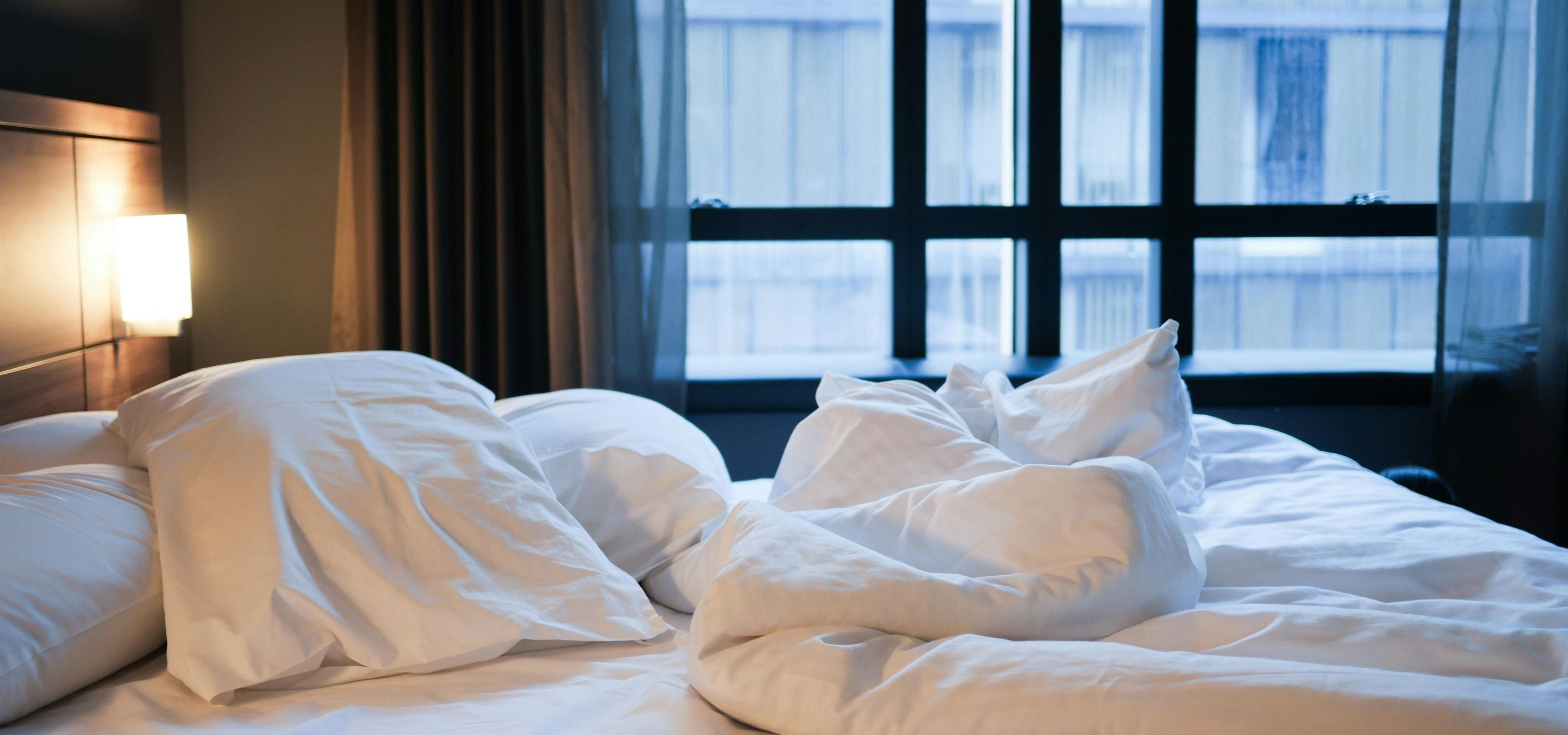 A luxurious, neatly made bed in a peaceful room, representing high-quality sleep environment optimization.
