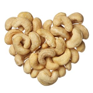 Raw cashews laid out on a surface in the shape of a heart.