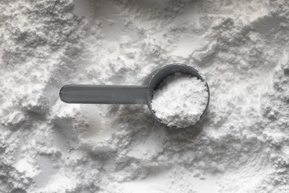 A scoop of protein powder representing casein or whey supplements.