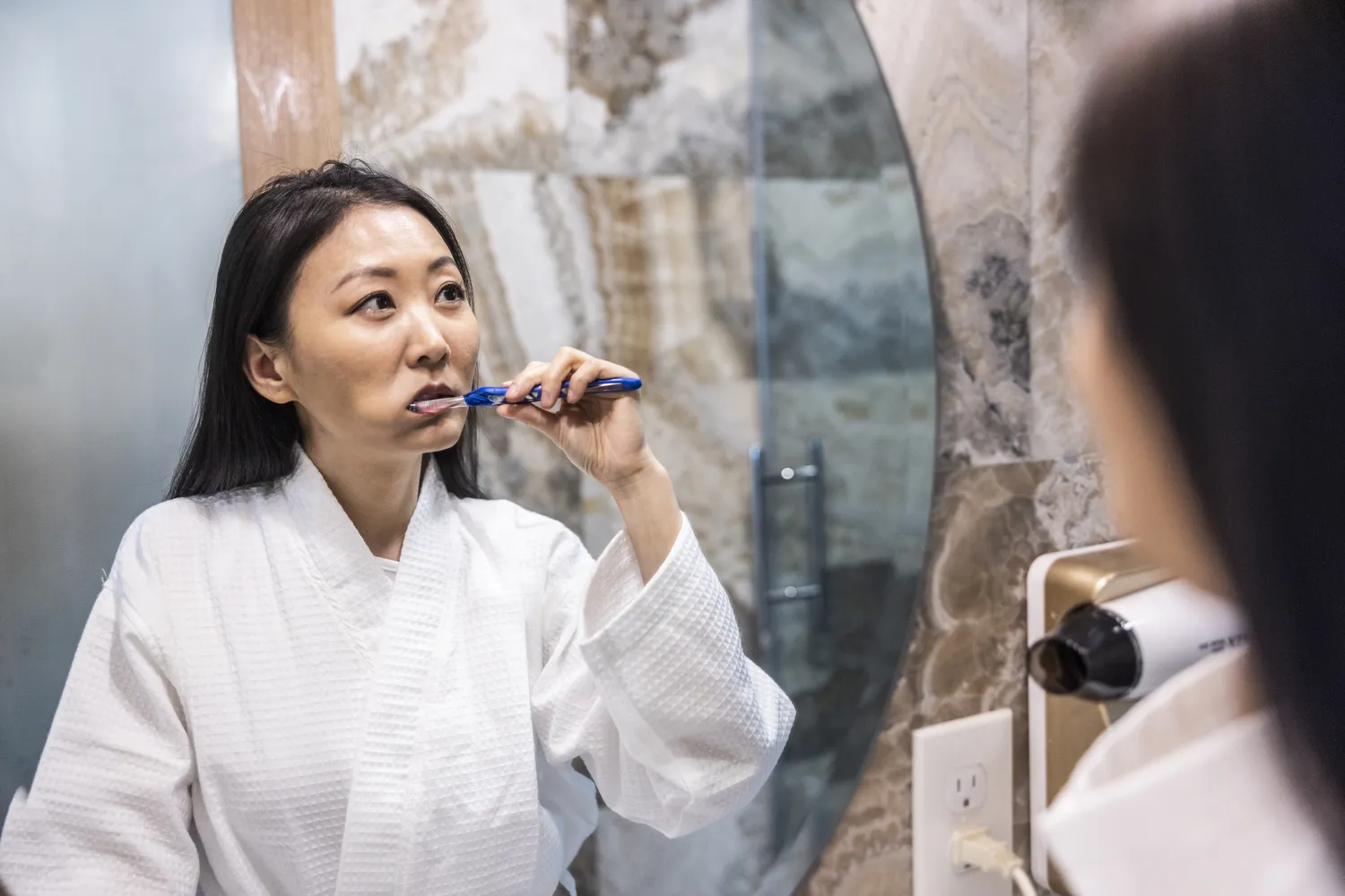 A person engaged in a daily hygiene routine, symbolizing behavioral consistency.