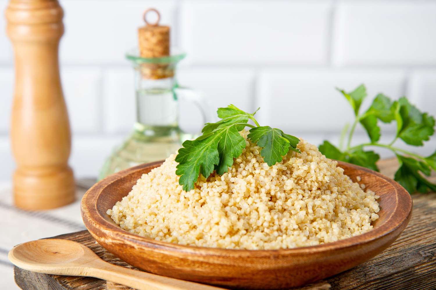 A wooden bowl filled with cooked quinoa, a nutrient-dense whole grain.