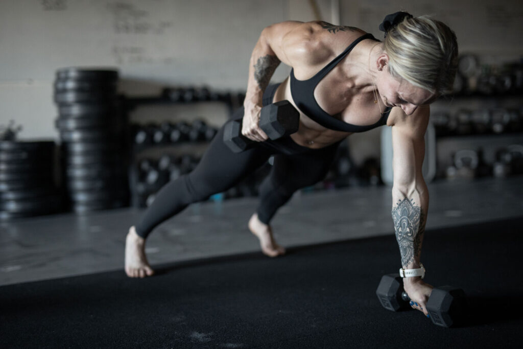 A woman performing strength exercises in a gym environment.