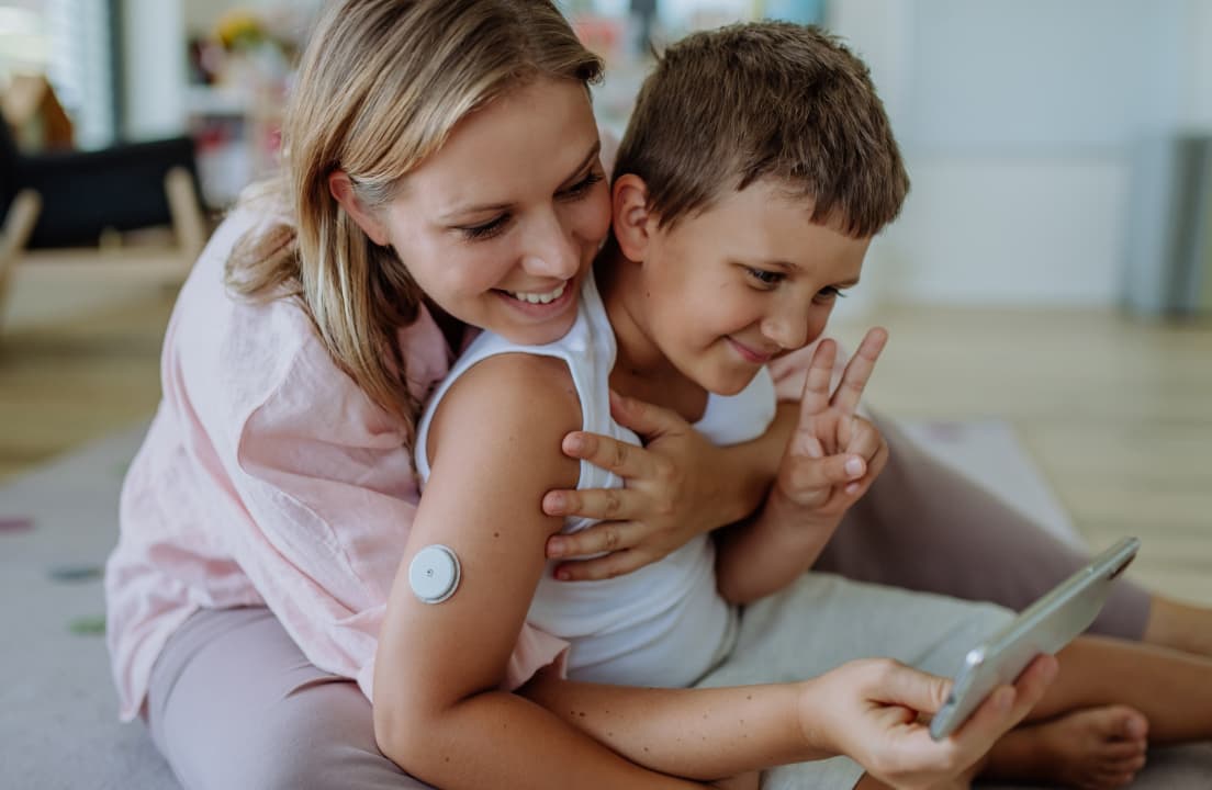 A mother and her son smiling together, representing the ease of managing health with modern diabetes technology.