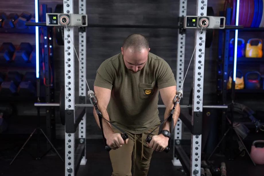 A man using the Voltra I portable cable machine for a chest fly exercise.