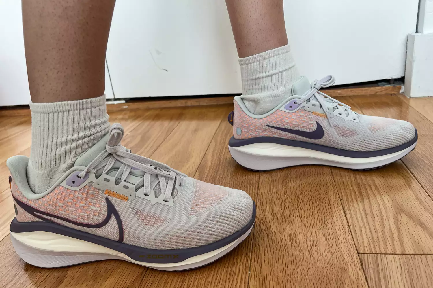 Close-up of a person standing in Nike shoes with thick ZoomX foam cushioning.