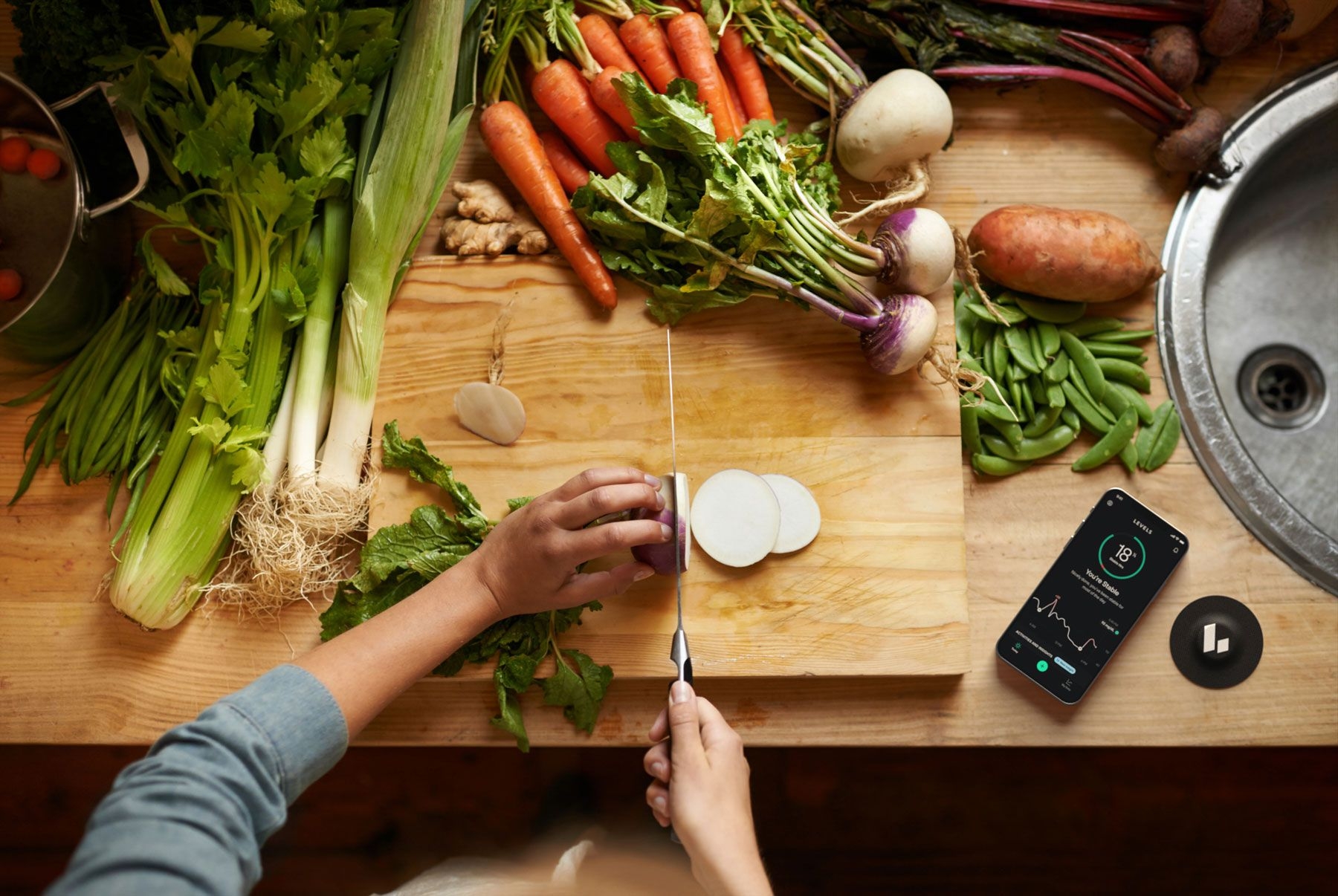 A person preparing a healthy meal with various green vegetables.