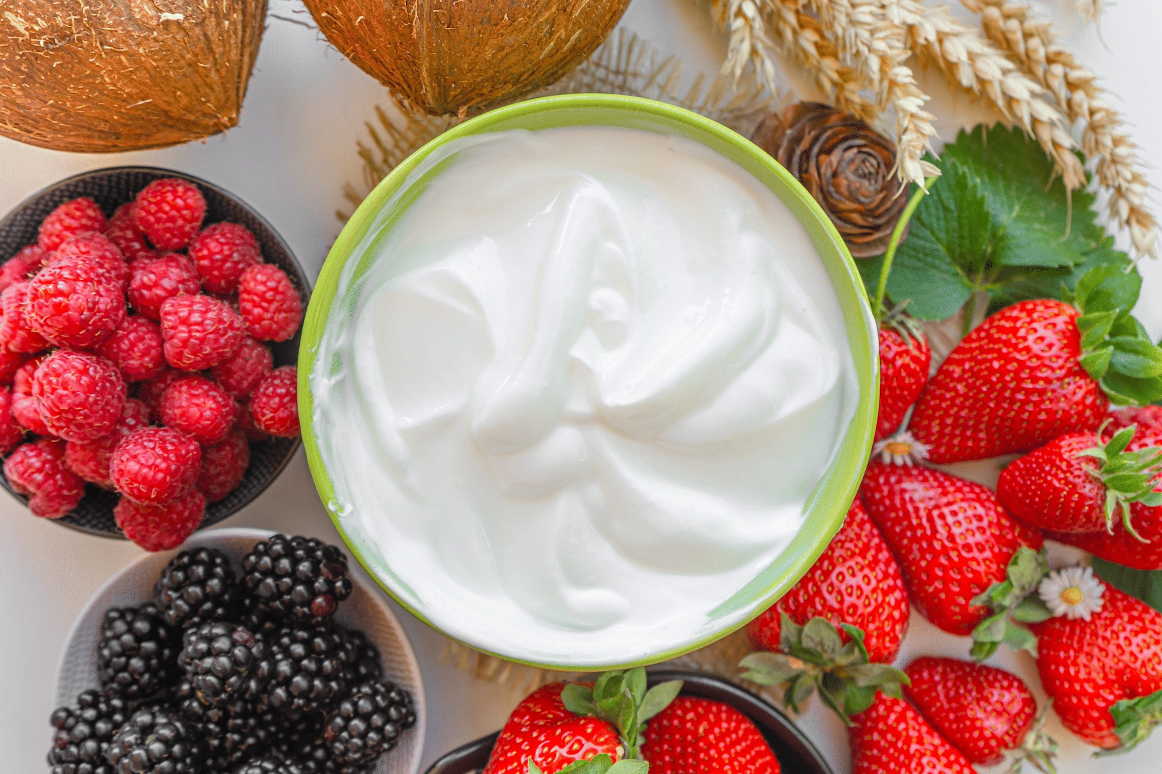 A bowl of Greek yogurt surrounded by fresh berries.