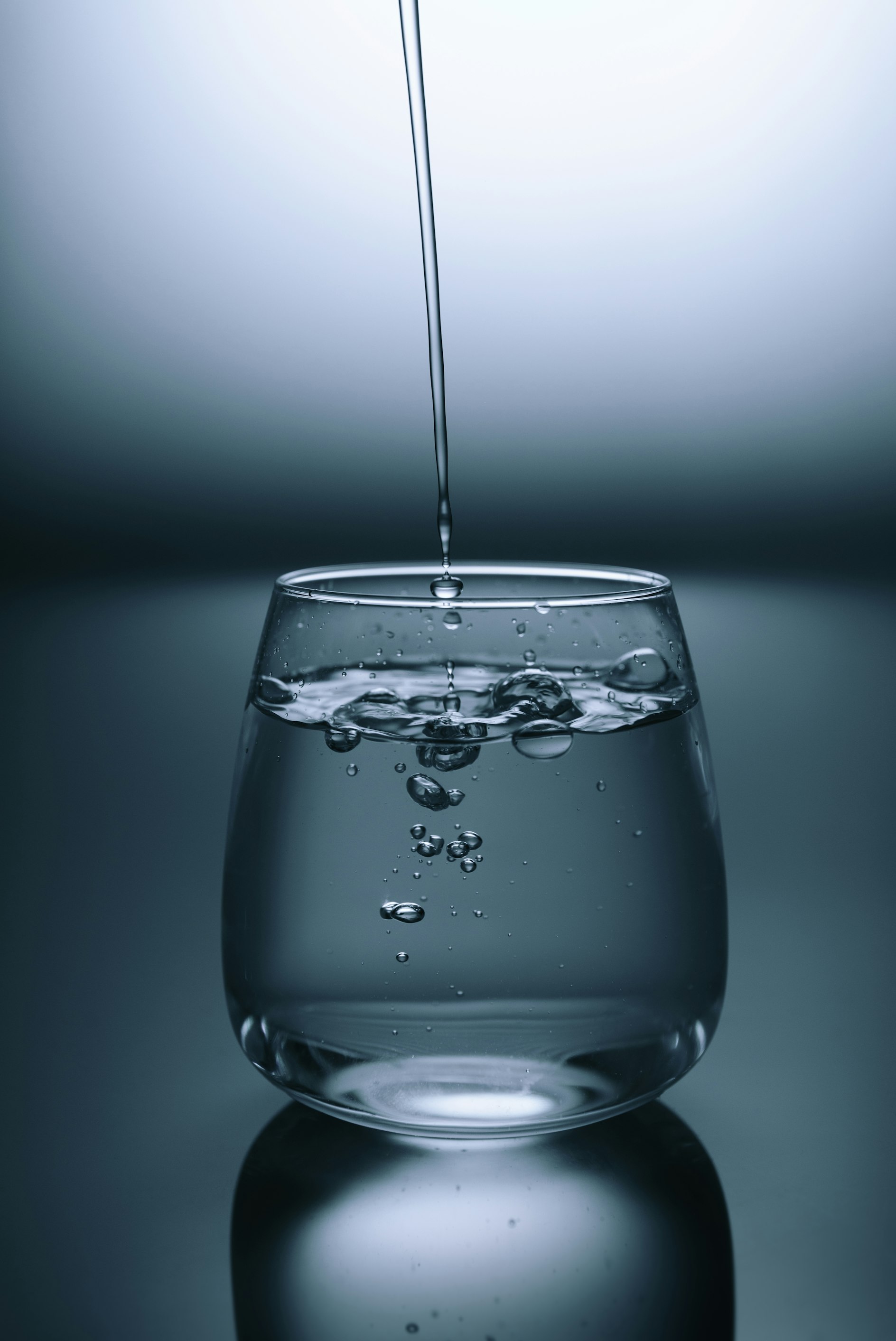 A tall glass of sparkling water with bubbles representing clean hydration.