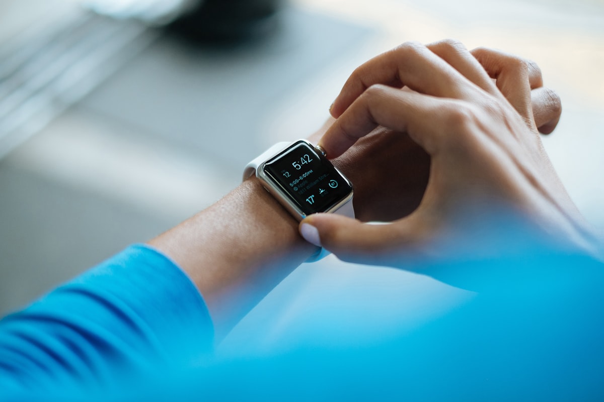 A close-up of a smartwatch on a wrist tracking heart rate and steps.