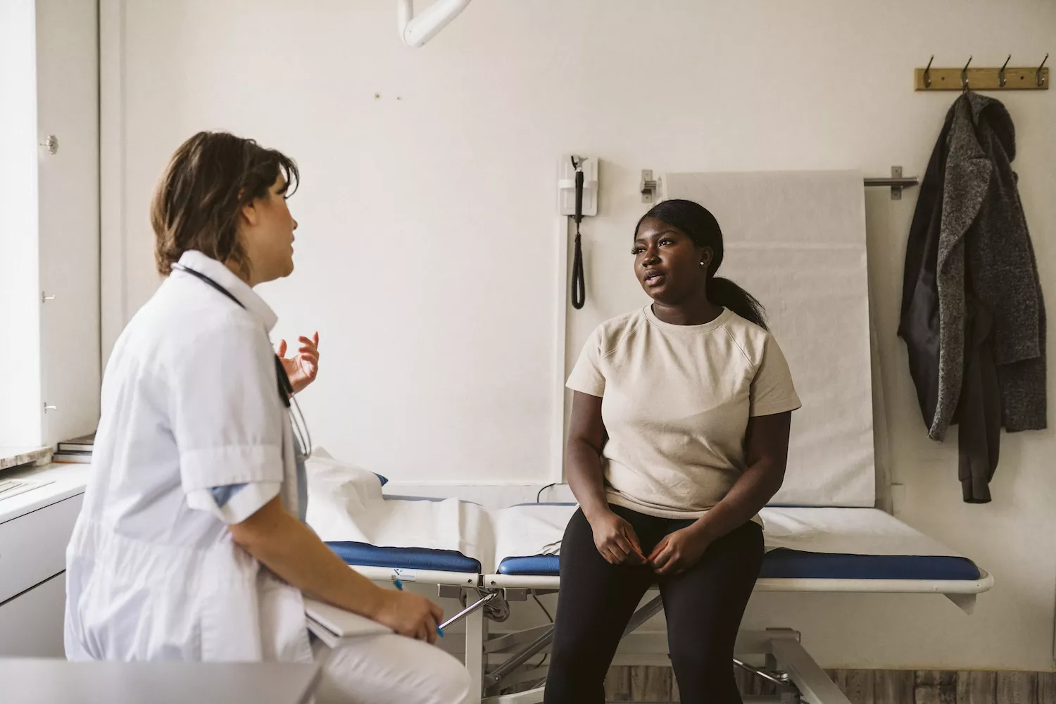 A woman discussing her health concerns and test results with a medical professional.