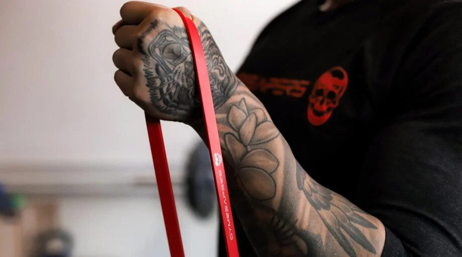 A close-up shot of a red latex resistance band wrapped around a hand to show material texture.