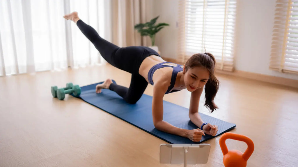 A woman in athletic wear performing gentle stretching exercises on a yoga mat at home.