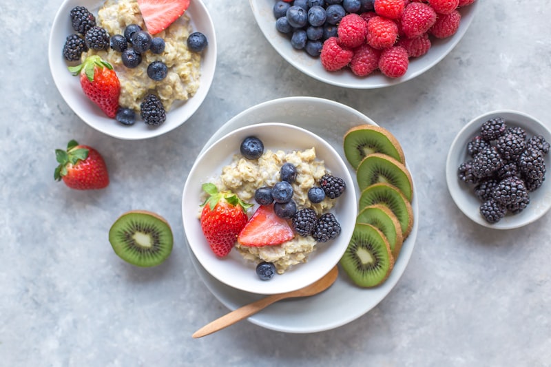 A warm bowl of oatmeal garnished with fresh blueberries and sliced nuts.
