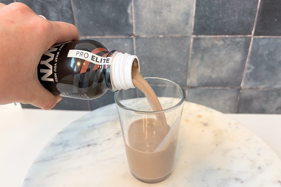 A bottle of OWYN Pro Elite plant-based shake with 32g protein prominently displayed.