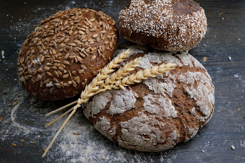 Several loaves of rustic whole grain bread and loose grains.