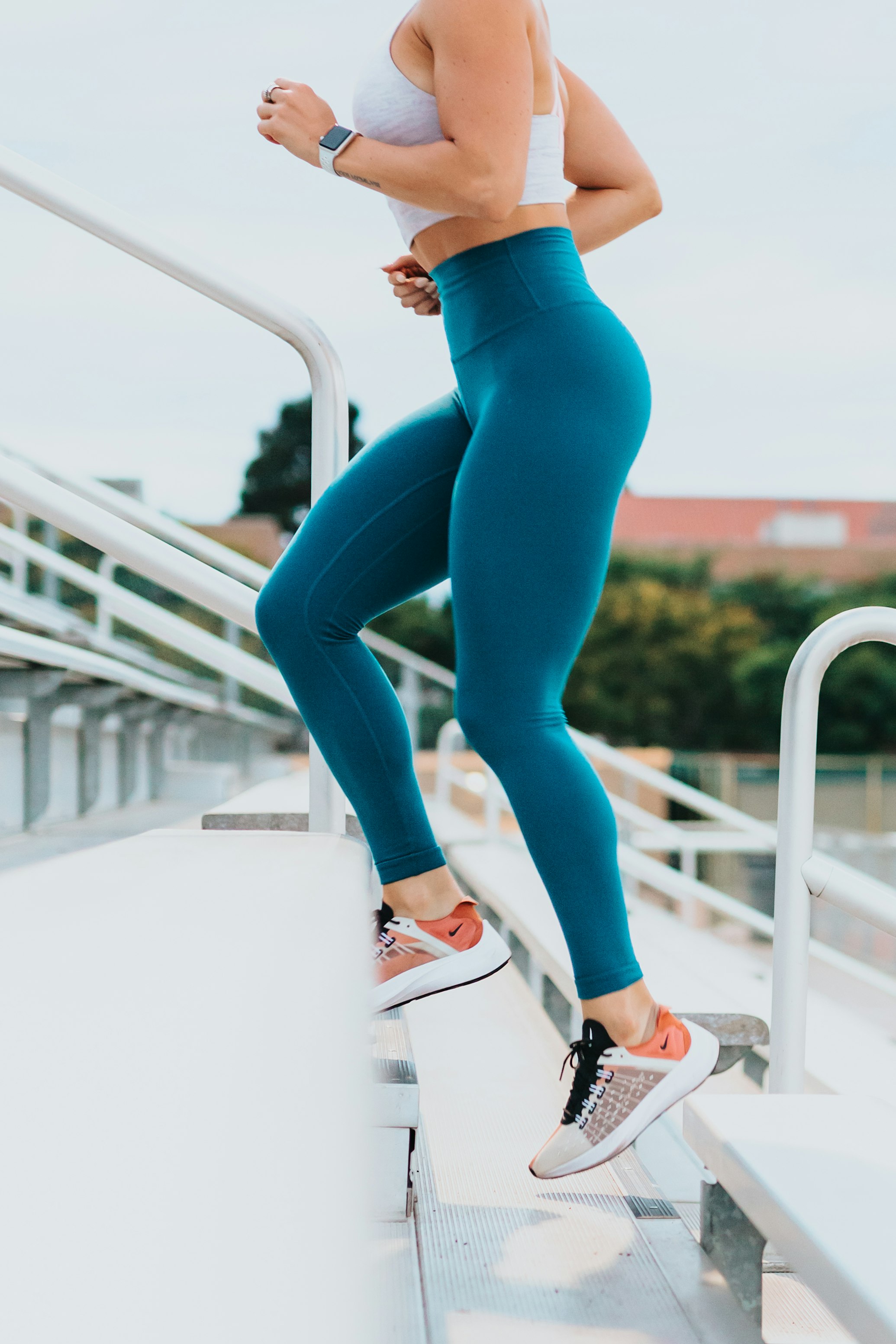 A person in athletic wear jogging through a green park during the day.