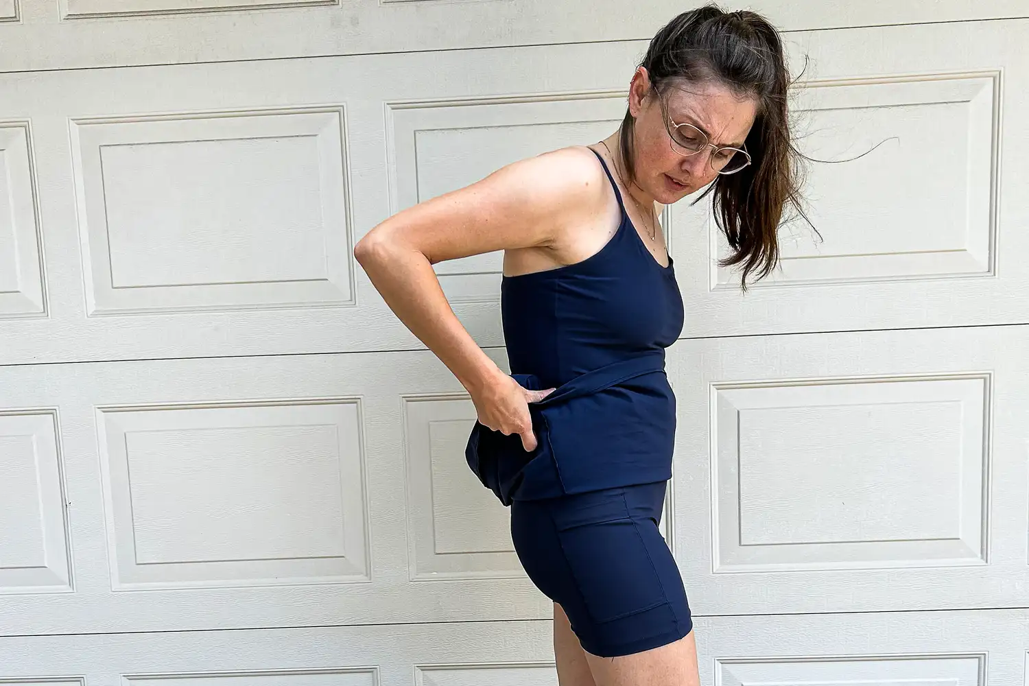 A person lifting the skirt of an Outdoor Voices exercise dress to reveal the built-in liner shorts.