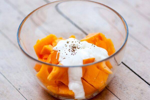 A healthy bowl filled with either Greek yogurt or cottage cheese topped with fresh fruit.